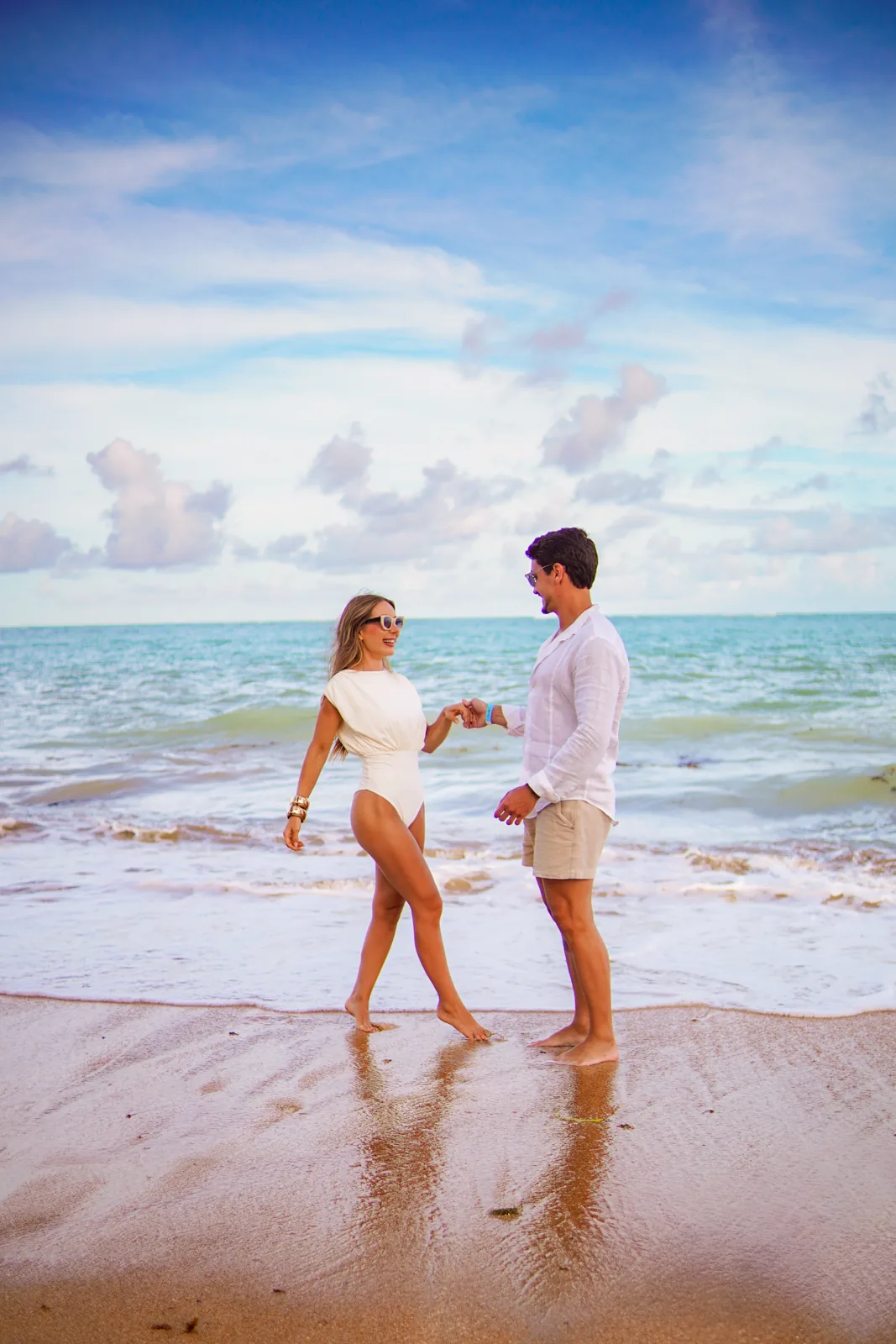 Casal caminhando junto ao mar de Milagres