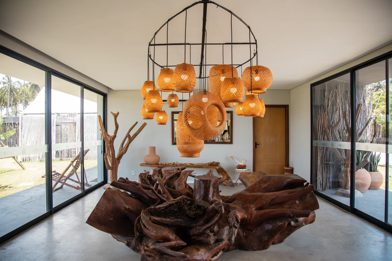 Hall do Taboo com luminárias de fibras naturais e mesa de madeira escultural