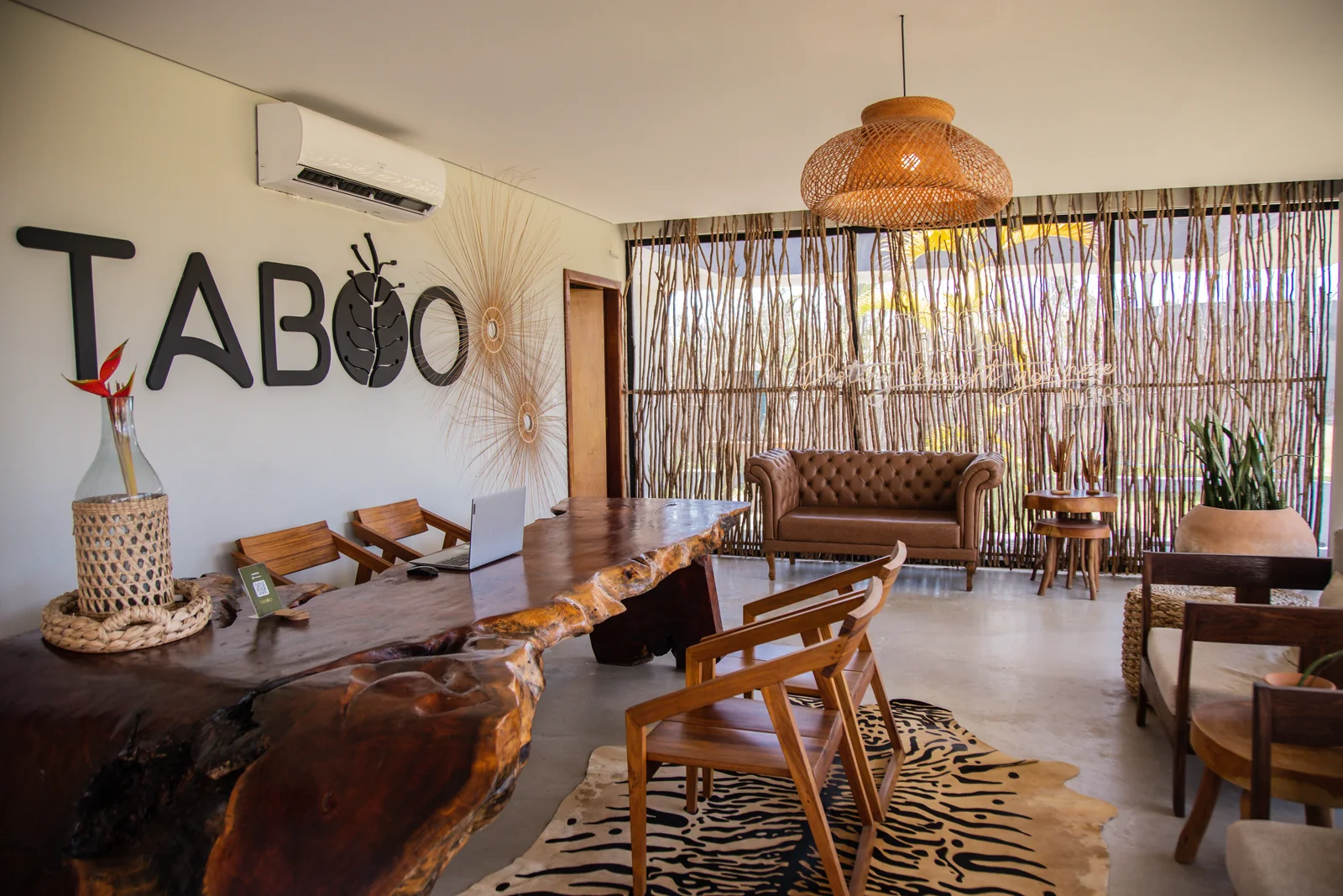 Recepção do Taboo com balcão de madeira e peças artesanais