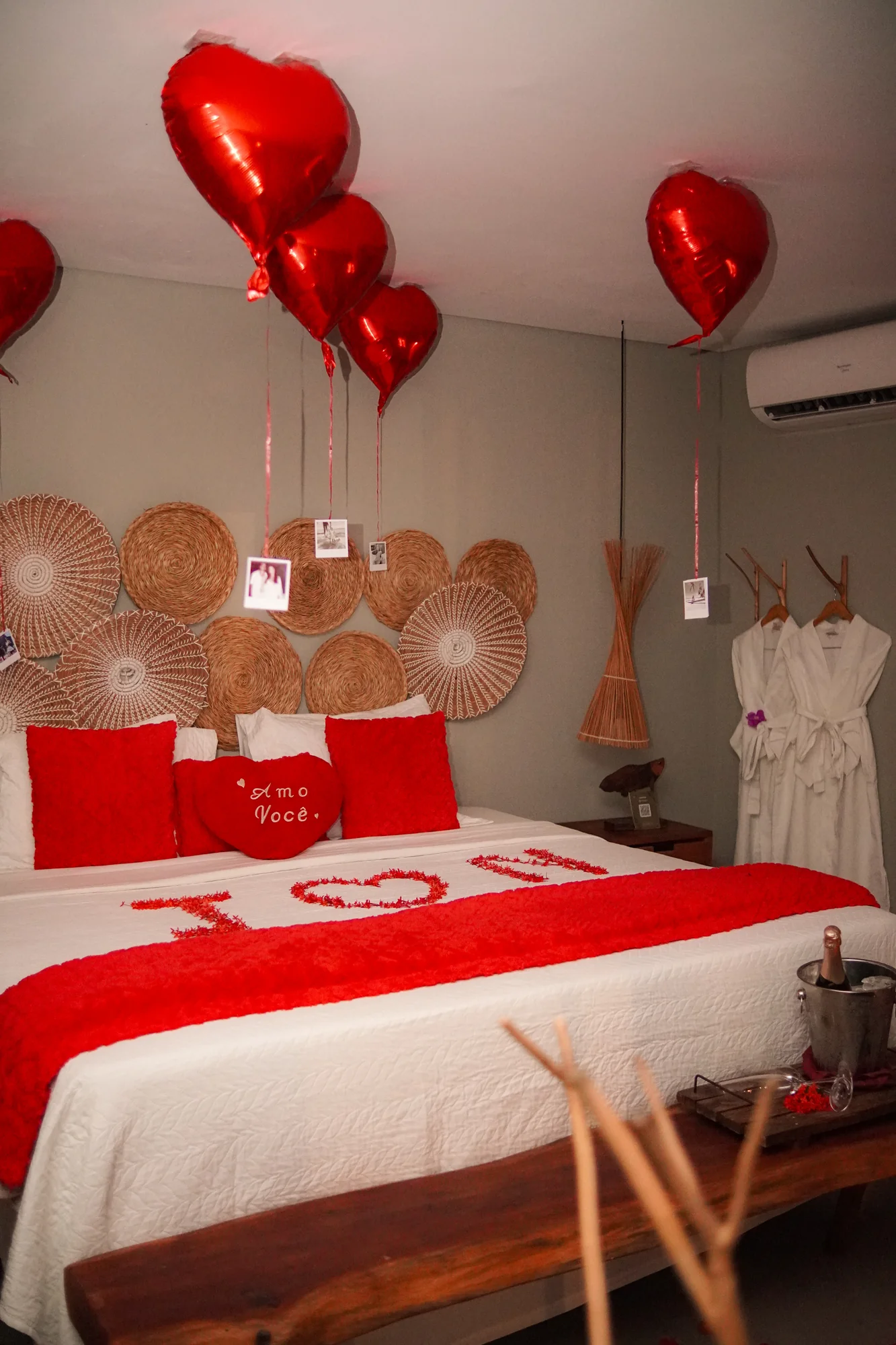 Suíte do Taboo com pétalas na cama e balões vermelhos em forma de coração